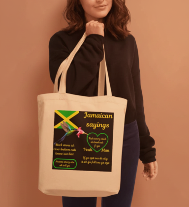A person holding a tote bag featuring Jamaican-themed artwork and a heart design.